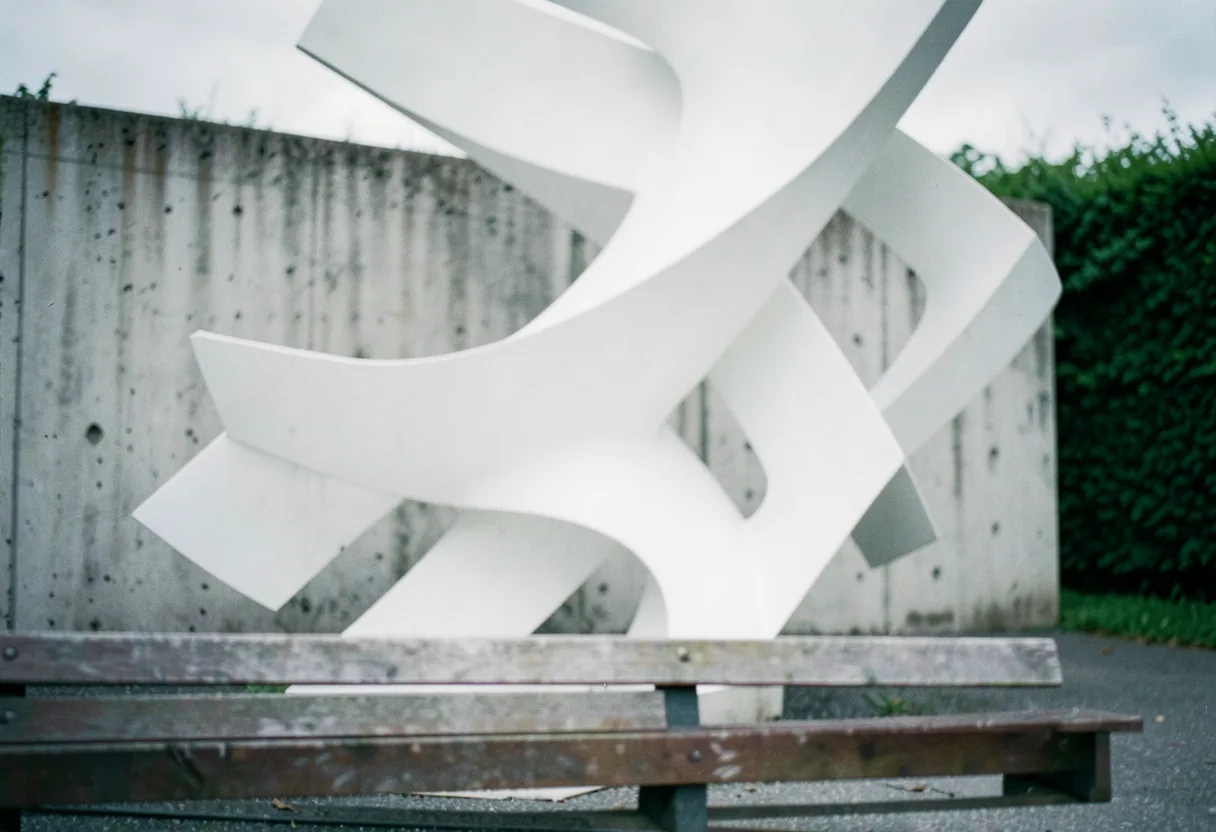 White geometric sculpture in muted, softly lit space. Abstract non objective art.